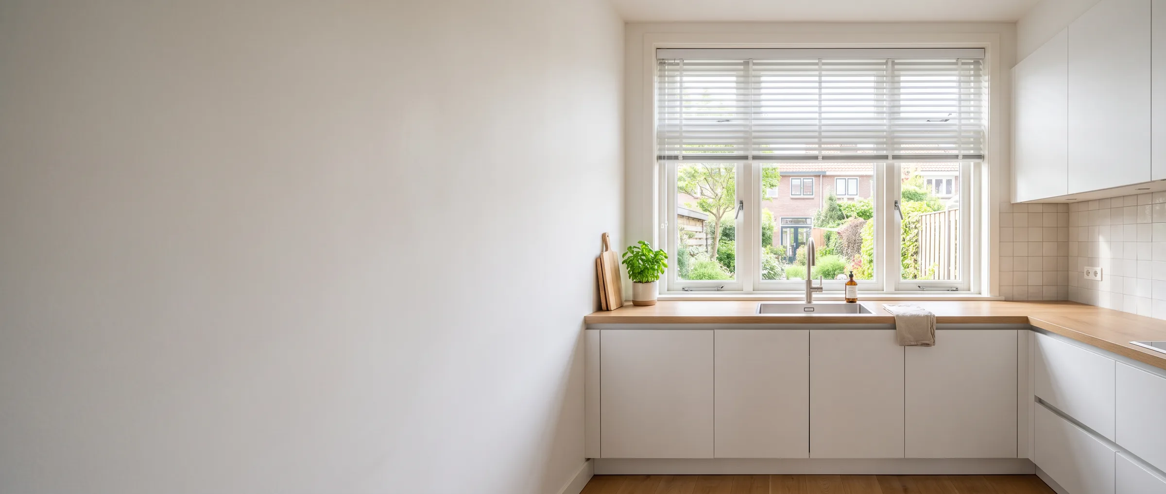 Lichte keuken met aluminium jaloezie boven het aanrecht