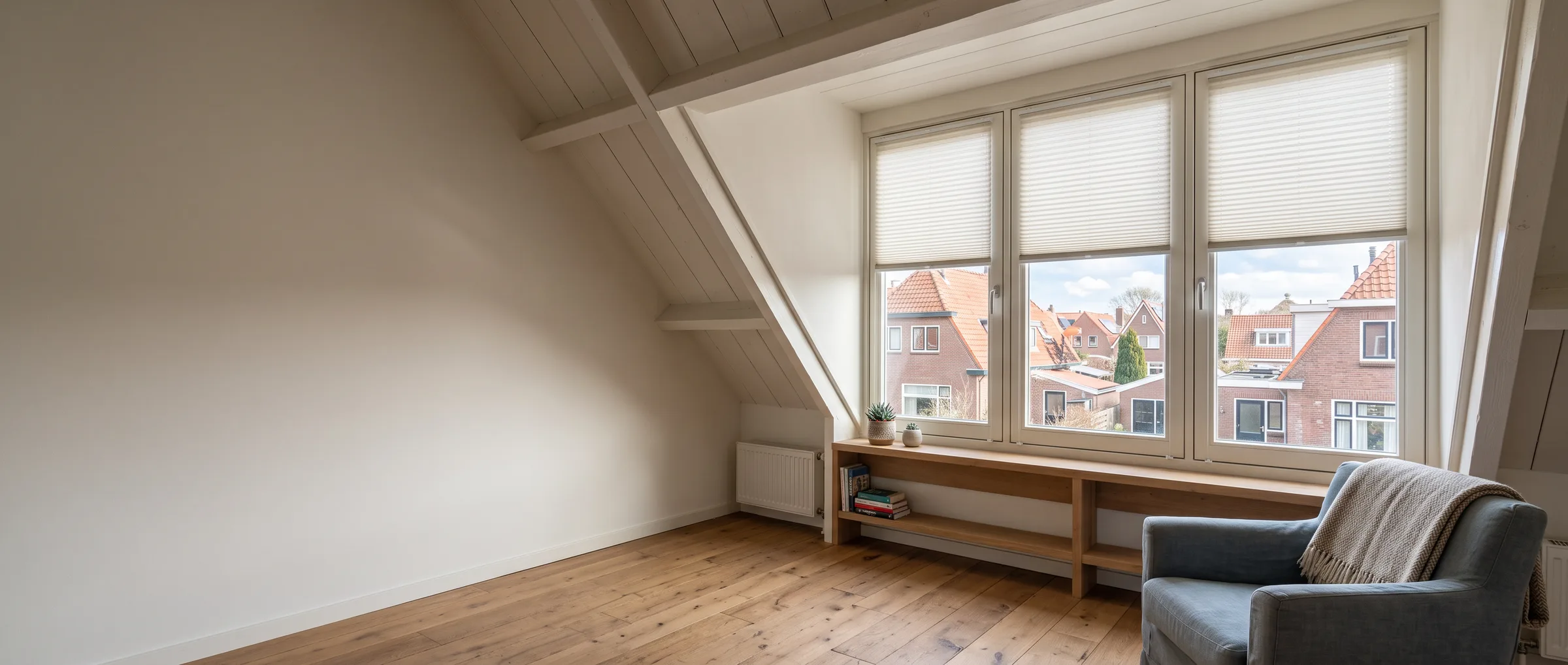 Zolderkamer met raamdecoratie in de dakkapel